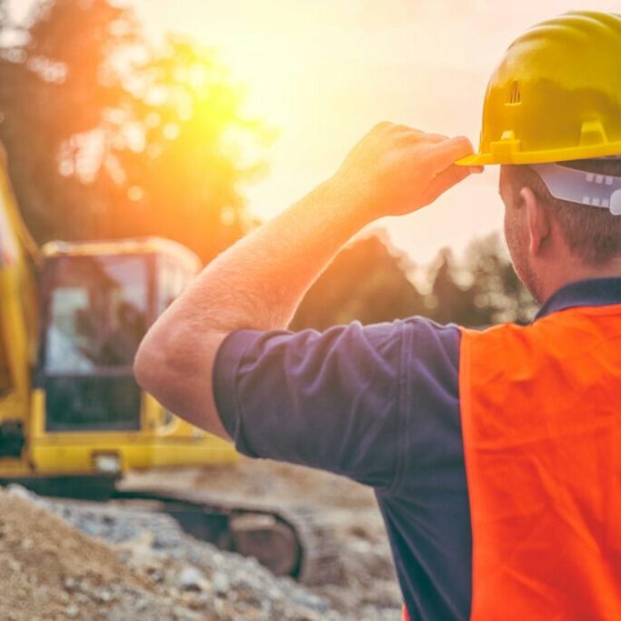 foreman watching over worker excavating